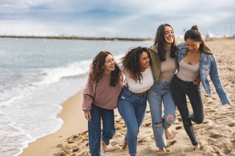 Women together at the beach, laughing and having a good time