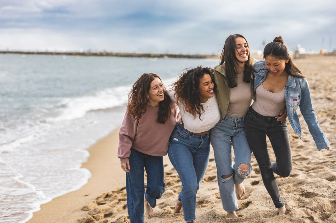 Women together at the beach, laughing and having a good time